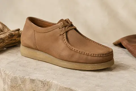 Mocassin homme Clarks Shacre II Run en cuir avec semelle en caoutchouc, présenté sur une pierre claire