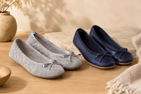 Deux paires de chaussons ballerines, gris clair matelassé et bleu marine uni, avec nœuds satinés.