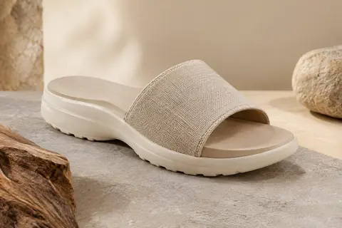 Mule PUMA Cool Cat 2.0 à enfiler, posée sur une surface minérale claire dans un décor naturel.