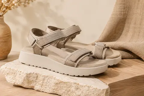 Sandales Skechers Reggae Slim Vacay à brides ajustables, présentées sur un support en bois clair.